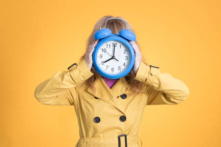 adult woman with alarm clock or alarm isolated on color backgroundの写真素材