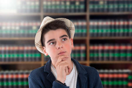 boy with thoughtful expression in the libraryの写真素材