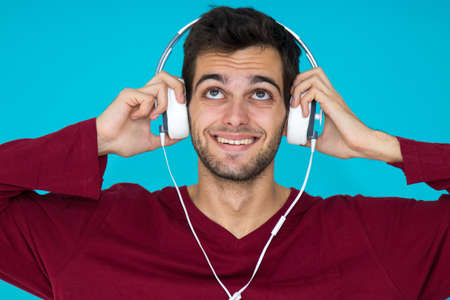 young man with headphones isolated on color background