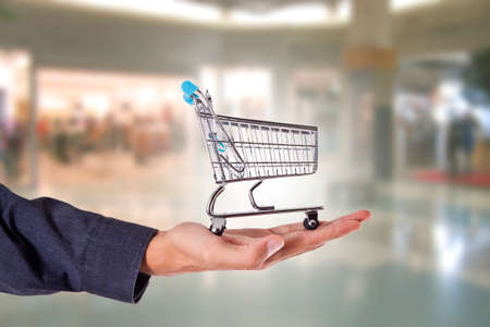 hand with shopping cart in store or mallの写真素材