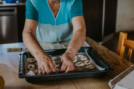 lady or grandmother preparing christmas candy or cakesの写真素材