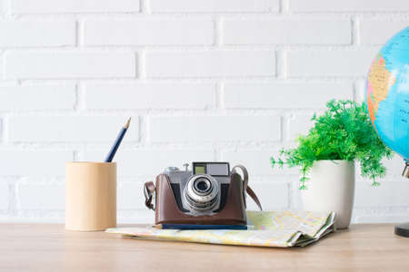 vintage photo camera with maps and pen on the deskの写真素材
