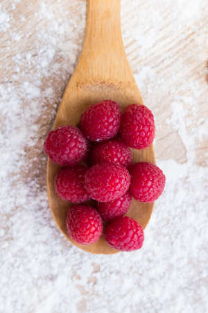 wooden spoon with natural red raspberries