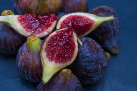 natural black figs grouped and open on black background
