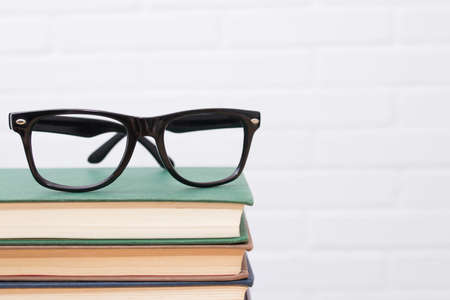 glasses on top of stacked books