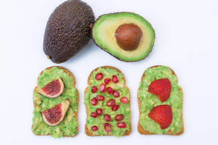 avocado or guacamole toast with natural red fruits