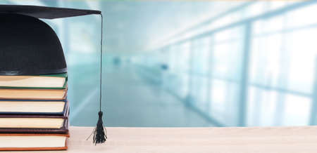 graduation cap and books stacked at schoolの写真素材