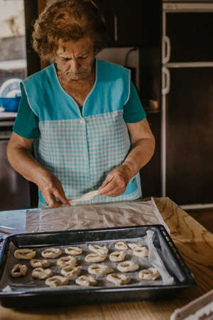 lady or grandmother preparing christmas candy or cakesの写真素材