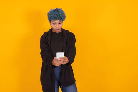 young afro american woman with mobile phone isolated on color background