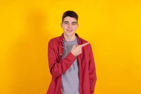 young teenager boy with shirt and casual shirt isolated on yellow backgroundの写真素材