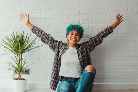 young african american girl or woman at home or apartment with arms raised in expression of success or freedomの写真素材