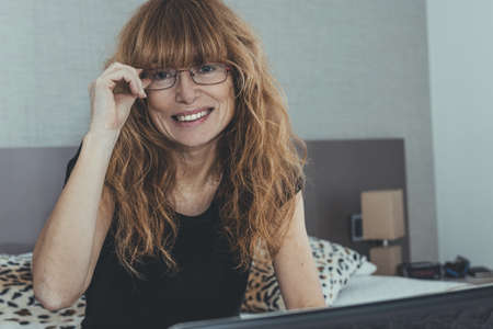 adult woman with laptop in the room or bedroomの写真素材
