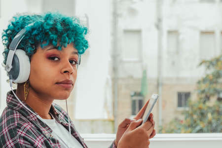 portrait of woman or girl with mobile phone and headphones