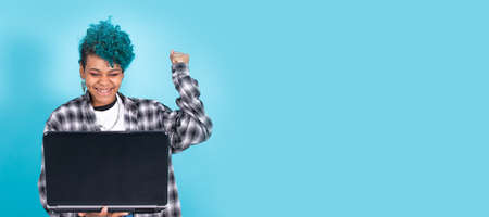 afro american girl with laptop computer isolated on blue backgroundの写真素材