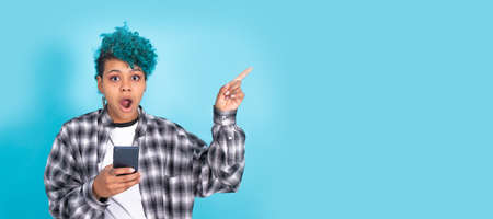 african american girl or woman with mobile phone or smartphone isolated on blue background