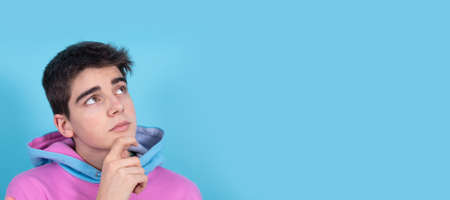 portrait of teenage student boy isolated on color background with thoughtful expression