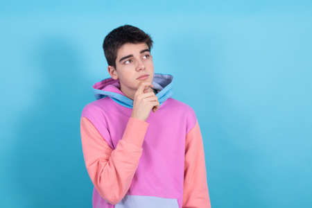 portrait of teenage student boy isolated on color background with thoughtful expressionの写真素材