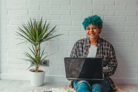 young girl or student at home with laptop sitting on the floorの写真素材
