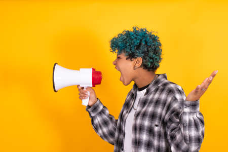 girl with megaphone isolated on color backgroundの写真素材