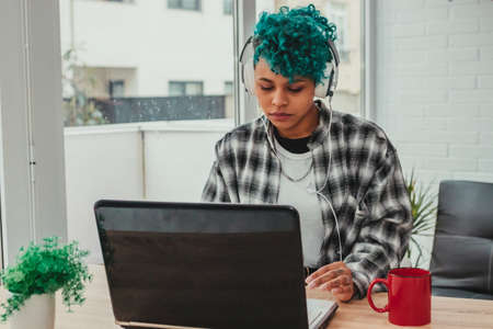 girl with computer and headphones at home or office desk