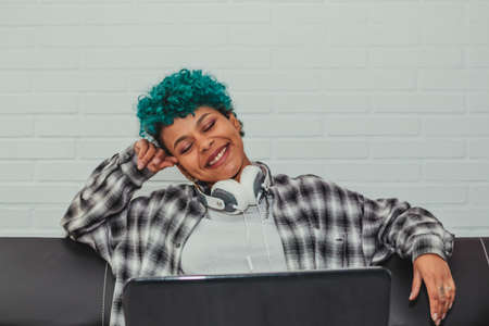 trendy young girl with laptop sitting on the sofaの写真素材