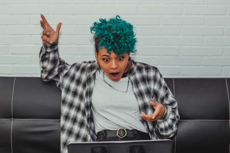 afro american girl looking at laptop with surprise or astonishment