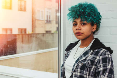 portrait of afro american brunette girl at home or office next to the windowの写真素材