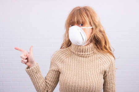 woman with mask on white wall backgroundの写真素材