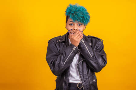 young modern brunette girl with curly blue hair of afro american ethnicity isolated on color backgroundの写真素材