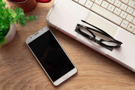 top view of mobile phone on desktopの写真素材