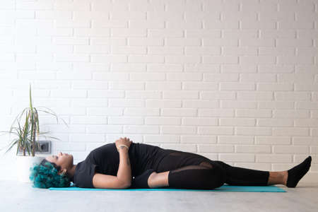 young woman wearing sportswear doing gymnastics at home or gym
