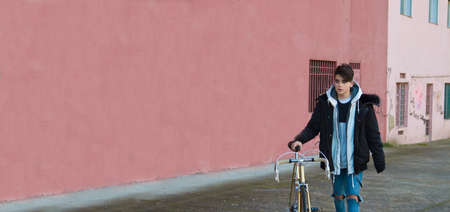 young teenager with bicycle on the street outdoorsの写真素材