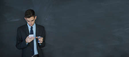 businessman with mobile phone and coffee cup with space for advertisement or textの写真素材