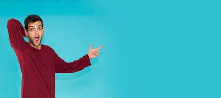 isolated amazed young man pointing color background spaceの写真素材