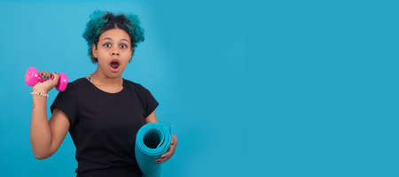 girl or woman doing sport with dumbbells on isolated color backgroundの写真素材