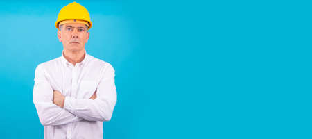 man isolated on color background with construction helmet
