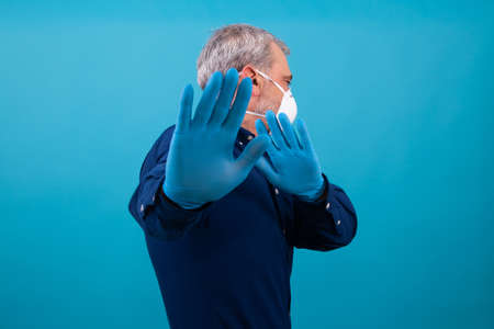 adult man with mask and gloves isolated on color backgroundの写真素材