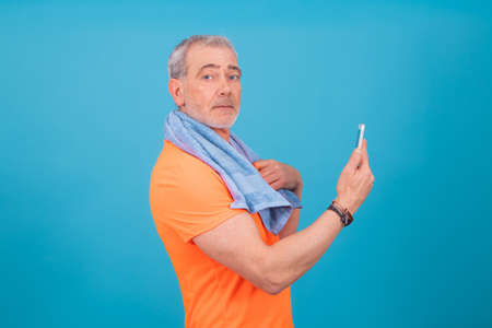 adult or senior man with mobile phone and sportswear isolatedの写真素材