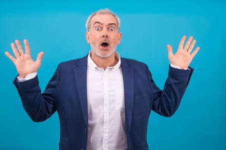 adult man with expression of surprise or amazement isolated on color backgroundの写真素材