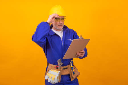 construction worker or professional isolated on color background with toolsの写真素材