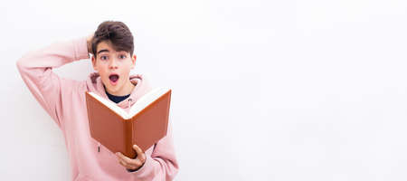male teenager student with book and expression of surprise isolated on white backgroundの写真素材