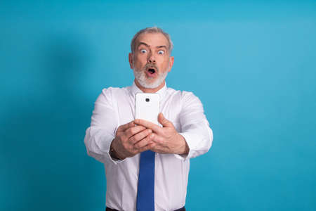 amazed isolated business adult man looking at mobile phoneの写真素材