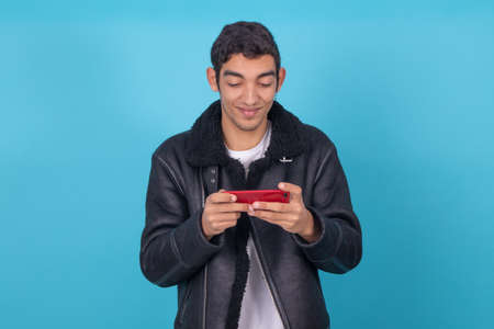 young man with mobile phone isolated on color background
