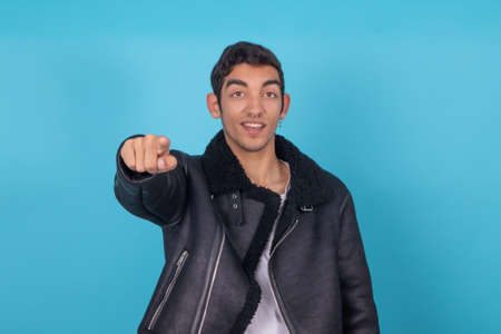 young man isolated on color background pointing with hand