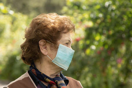 senior woman with face mask protected from contagion outdoorsの写真素材