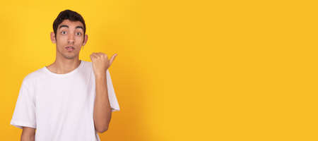 young teenager pointing surprised isolated on background with space