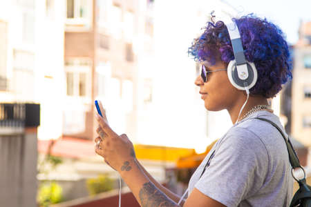 girl with phone and headphones outdoors in the cityの写真素材