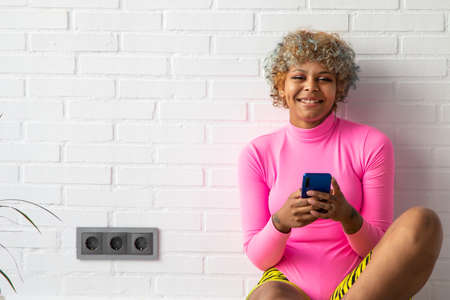 woman with sportswear and mobile phone at home or gym
