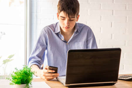 teenage student with mobile phone and computerの写真素材
