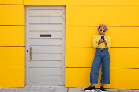 afro american girl with mobile phone on the streetの写真素材